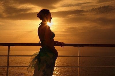 Frau auf einem Schiff bei Sonnenuntergang