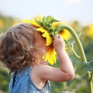 Mädchen mit Sonnenblume im Feld