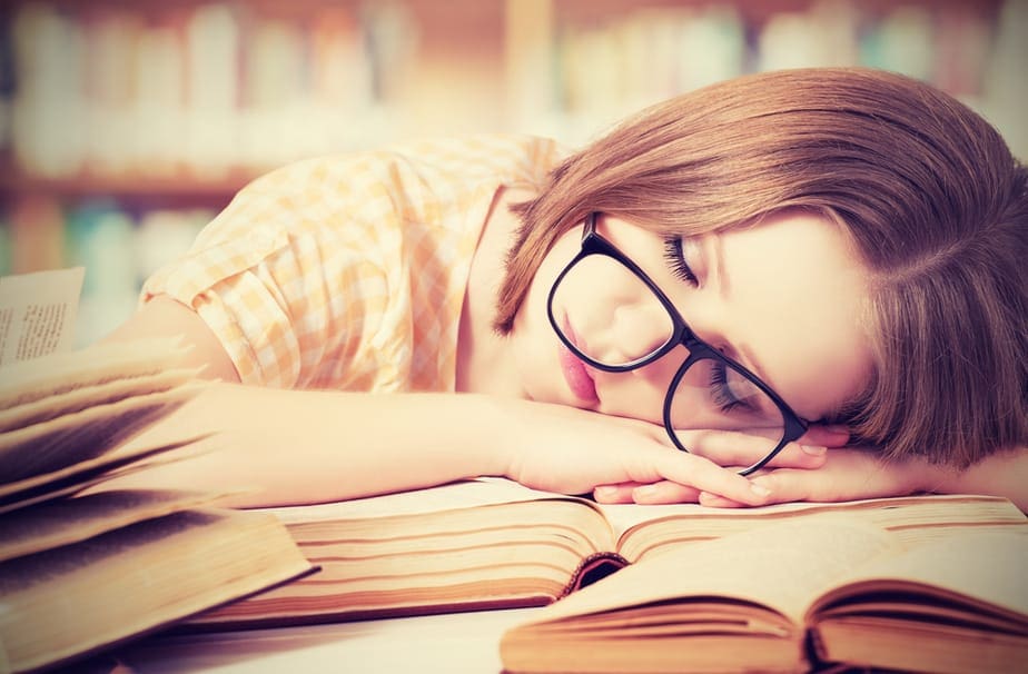 Studentin schläft über Büchern.