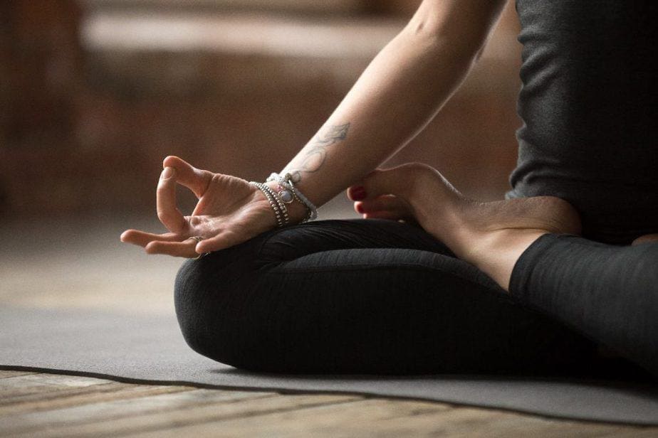 Frau meditiert in Padmasana auf Yogamatte