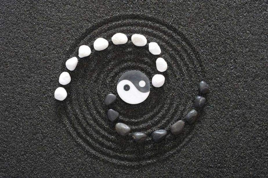 Yin Yang Symbol mit Steinen im Sand