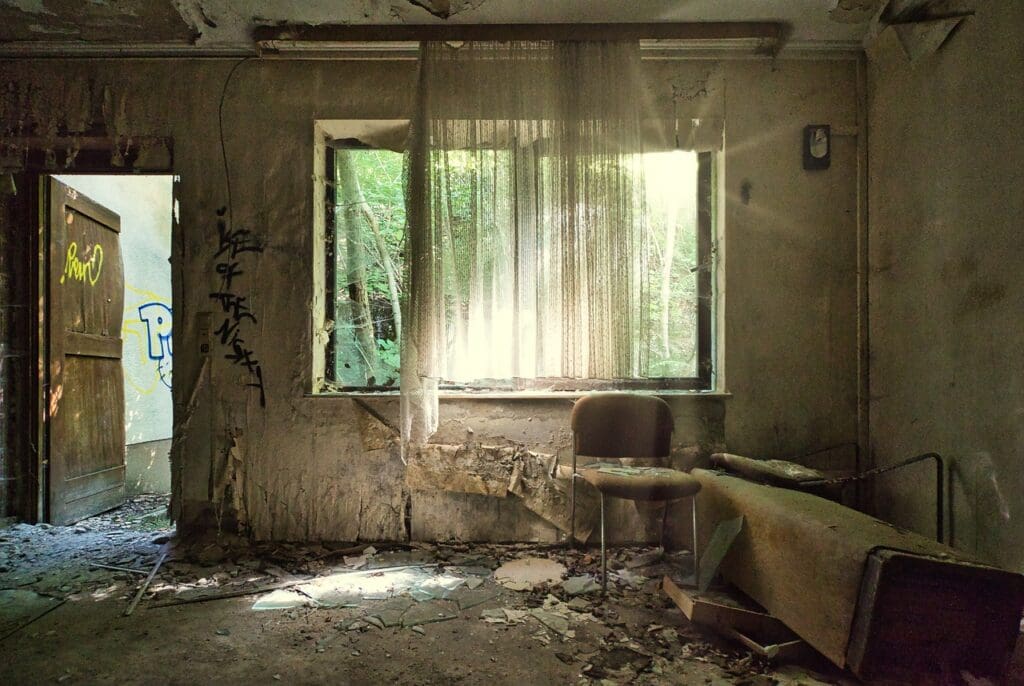 Verlassenes Zimmer mit Stuhl und Graffiti.